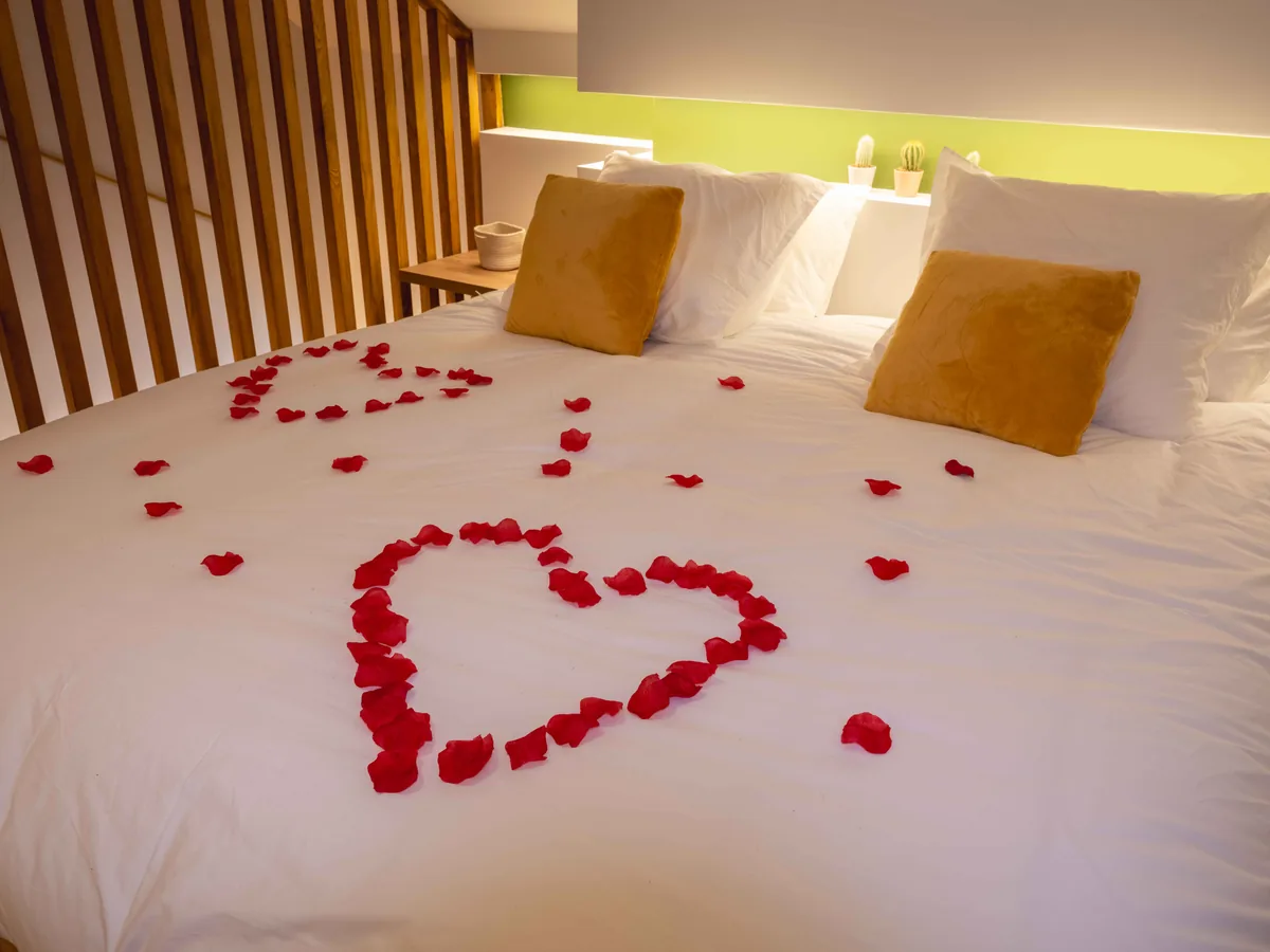 Chambre romantique avec pétales de roses — La Parenthèse suite privée Essonne