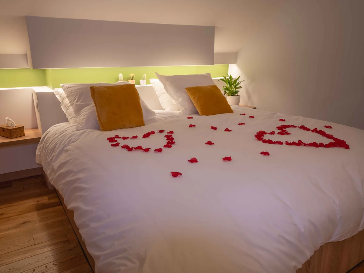 Chambre king-size avec pétales de roses — suite romantique Essonne