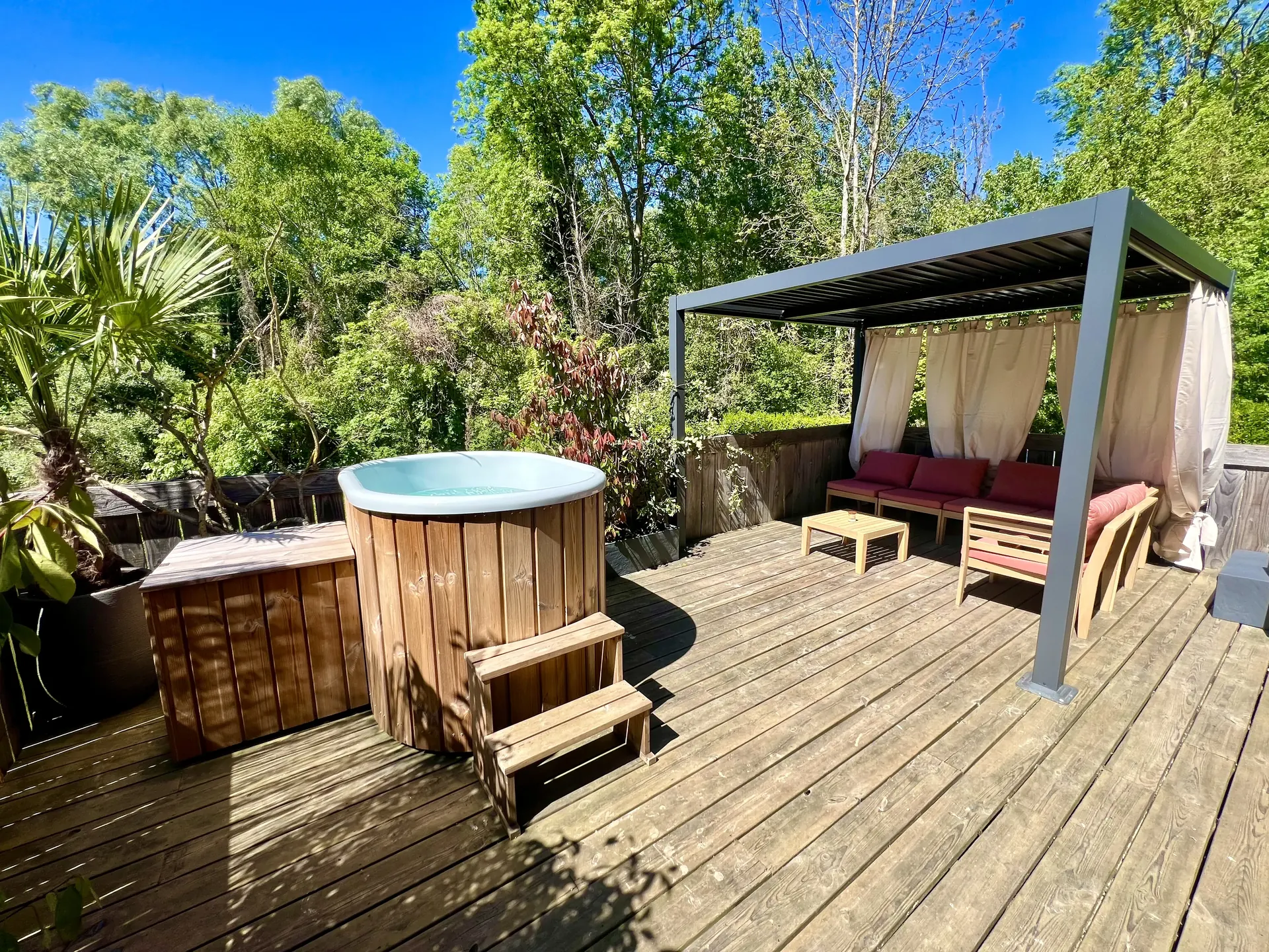 Terrasse privée en été avec bain nordique, pergola bioclimatique et salon de jardin — La Parenthèse